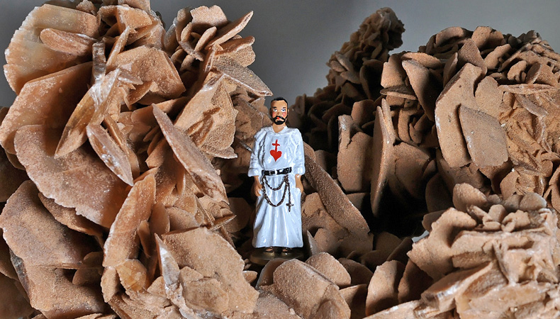 Figurine en plomb du Père Charles de Foucauld posée à l’intérieur d’une grosse rose des sables, provenant du Sud Sahara